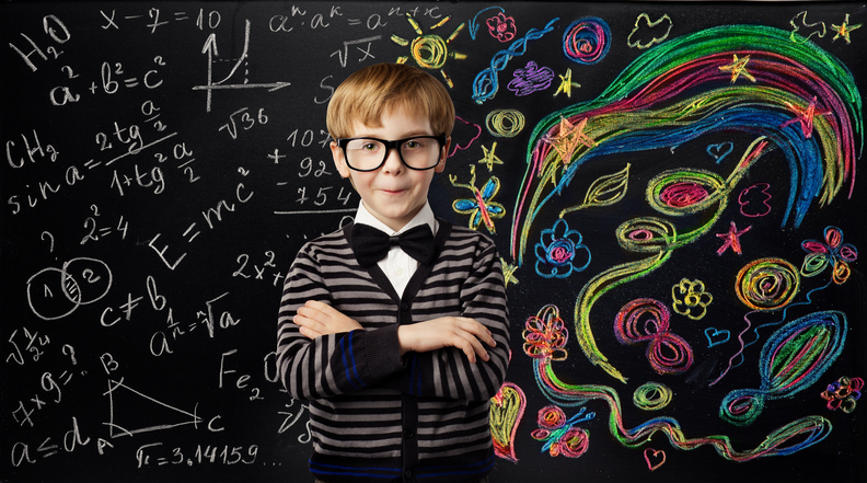 Photographie d'un enfant devant un tableau noir. Le tableau à sa droite est rempli de formules mathématiques et à sa gauche, d'illustrations colorées artistiques.